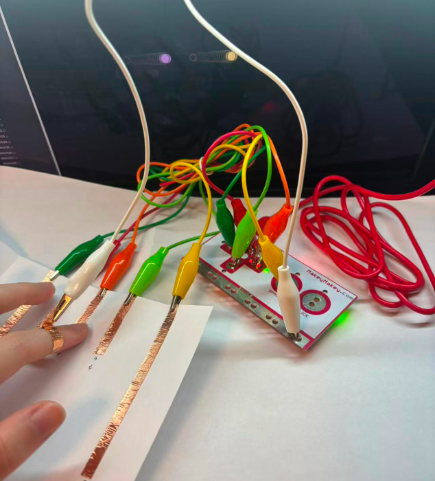By using copper strips to connect the circuit with MakeyMakey, the control and visual effects can interact. (Hand connection